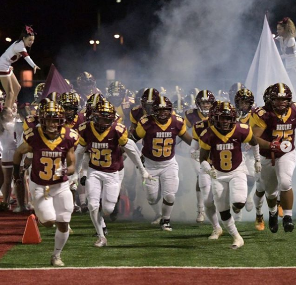 Seniors, Peter Sio (31), Jerimiah Artis (23), Jorge Jimenez (56), and Junior Tyrie Robinson (8) enter the field as they sprint down a line of fog, cheerleaders, bruinettes, and band members.


