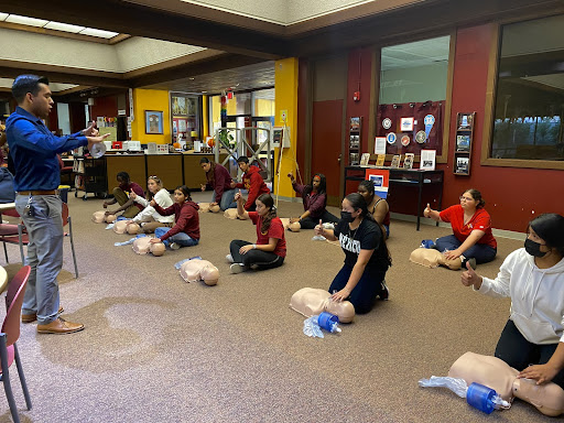 Mathew Martinez and Wilson kids getting ready to use a CPR mannequin. 