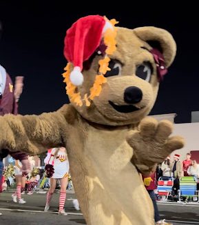 Mascot Wilma showing her holiday spirit at the Belmont Parade while marching band and Bruinettes get ready in the back.